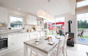 a white kitchen with a table and a fireplace at Haus zum maritimen Blick in Wandlitz
