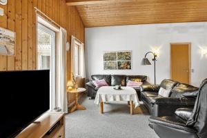 un soggiorno con mobili in pelle e una TV a schermo piatto di 560-Thisted-Klitrosevej-60 a Thisted