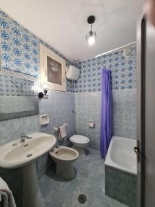 a blue tiled bathroom with a sink and a toilet at Casa alta in Allerona