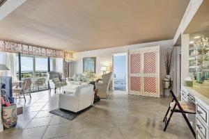 een grote woonkamer met een witte bank en stoelen bij Luxury Two-Bedroom Oceanfront Apartment With Panoramic Views in South Palm Beach