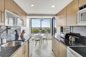 een keuken met een tafel en een groot raam bij Luxury Two-Bedroom Oceanfront Apartment With Panoramic Views in South Palm Beach