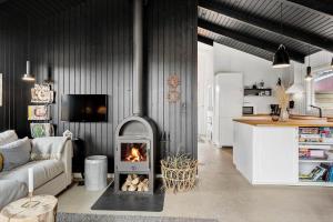 a living room with a fireplace in the middle at 1014-Thisted-Sletningen-7 in Torsted