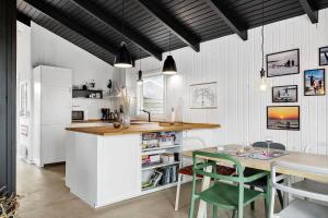 a kitchen with a counter and a table and chairs at 1014-Thisted-Sletningen-7 in Torsted