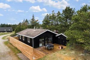 a black house with a wooden deck in a field at 1014-Thisted-Sletningen-7 in Torsted