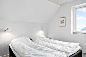 1 cama no hecha en una habitación blanca con ventana en 794-Thisted-Havstokken-26-1, en Thisted