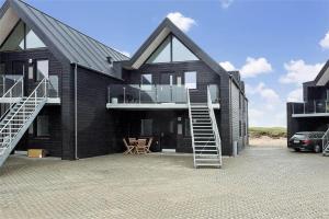 una casa negra con una escalera delante en 794-Thisted-Havstokken-26-1, en Thisted