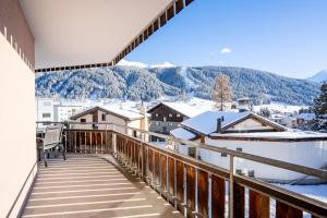 Un balcón con vista a las montañas cubiertas de nieve. en A&Y Alpenchique Apartment Davos, en Davos