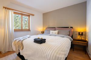 Un dormitorio con una cama con una maleta encima. en A&Y Alpenchique Apartment Davos, en Davos