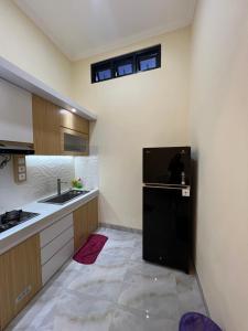 a kitchen with a black refrigerator and a sink at Tentrem Madani in Yogyakarta +6 photos
