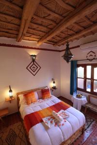 Un dormitorio con una cama grande en una habitación. en Maison d'Hôte Argana, en Aït Idaïr