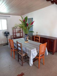 a dining room table with a vase with a plant on it at la bella vita in Port-Louis