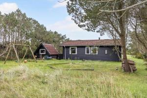 una casa en un campo con un columpio en 912-Thisted-Astien-17, en Torsted