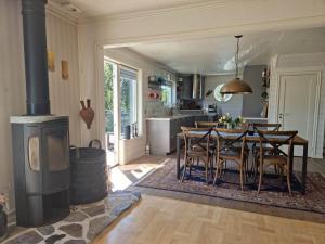 a kitchen and dining room with a table and a stove at Lovely view & walking distance to the beach SE09150 in Svanesund