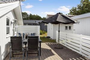 un tavolo con un ombrellone accanto a una staccionata bianca di 232-Thisted-Klitrosevej-64 a Thisted