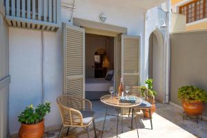 eine Terrasse mit Tisch und Stühlen und ein Schlafzimmer in der Unterkunft Arokaria Studios in Gaios