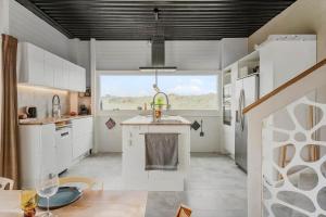 a kitchen with white cabinets and a large window at 302-Snedsted-Klitfogedvej-7 in Snedsted