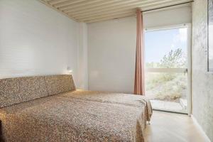 a bedroom with a bed and a large window at 302-Snedsted-Klitfogedvej-7 in Snedsted