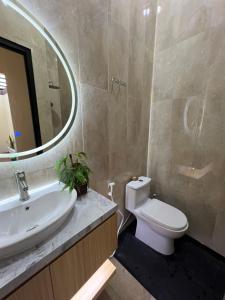 a bathroom with a sink and a toilet and a mirror at Tentrem Madani in Yogyakarta