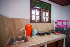 een aanrecht met een wastafel en een raam bij jenul villa in Ahangama +16 foto's