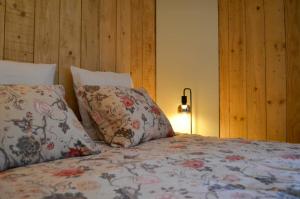 a bedroom with a bed with two pillows and a lamp at Le Relais d'Hubert in Saint-Hubert