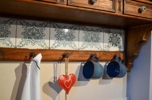 a kitchen with utensils and a heart on a wall at Le Relais d'Hubert in Saint-Hubert