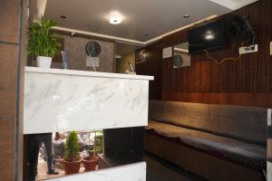 Grand sapphire 100 meters from Sub urban Bus stand Mysore في ميسور: غرفة انتظار بها مقاعد ومنضدة بها نباتات