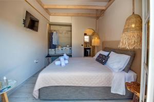 ein Schlafzimmer mit einem Bett mit weißen Laken und Kissen in der Unterkunft Arokaria Studios in Gaios