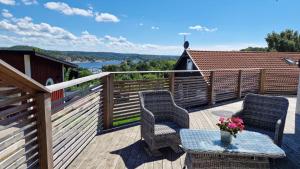 two chairs and a table on a deck with a view at Modern Cottage with Sea View in Svanesund SE09151 in Svanesund