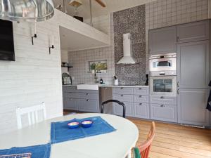 a kitchen with a white table with blue dishes on it at Modern Cottage with Sea View in Svanesund SE09151 in Svanesund