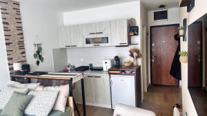 a small kitchen with white cabinets and a table at Studio Nordik in Divčibare