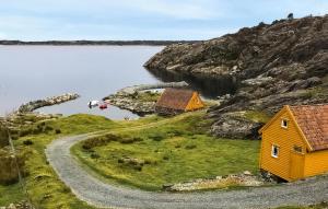 a house on a hill next to a body of water at Holiday Home Finnås Lykling in Lykling