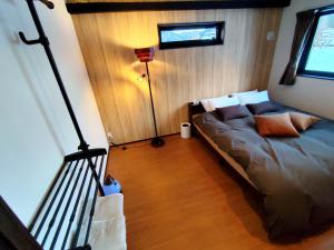 Nest SETSUGEN Villa في هاكوبا: غرفة نوم بسرير ومصباح ارضي