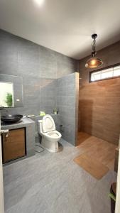 a bathroom with a toilet and a sink at No 5 Home in Ratchaburi