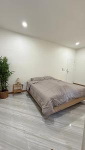 a bedroom with a large bed in a white wall at No 5 Home in Ratchaburi