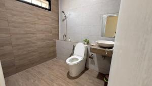 a bathroom with a toilet and a sink at No 5 Home in Ratchaburi +5 photos