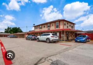 a building with cars parked in a parking lot at The Mint Motel in Arlington