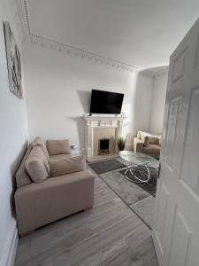Casa Fresa - 31A High Street في Monifieth: غرفة معيشة مع أريكة ومدفأة