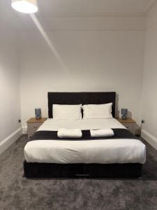 Casa Fresa - 31A High Street في Monifieth: غرفة نوم بها سرير كبير وطاولتين جانبيتين