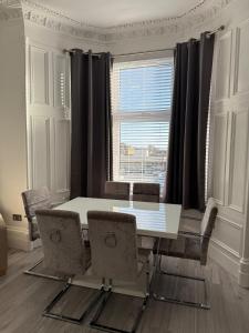 Casa Fresa - 31A High Street في Monifieth: غرفة طعام مع طاولة بيضاء وكراسي