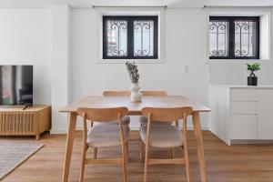 una mesa de comedor con 2 sillas y un jarrón. en Private Garden Oasis, A Charming Flat in Bonfim, en Bicas