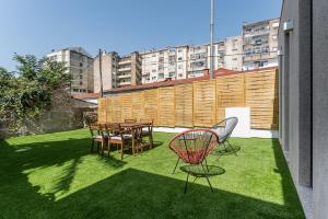 Un balcón con una mesa y sillas en el césped en Private Garden Oasis, A Charming Flat in Bonfim, en Bicas