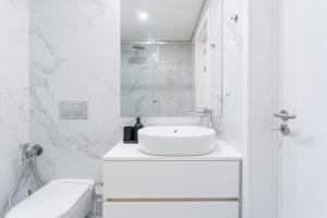 Un baño blanco con lavabo e inodoro. en Private Garden Oasis, A Charming Flat in Bonfim, en Bicas 25 fotos más