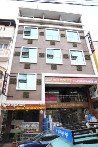 Grand sapphire 100 meters from Sub urban Bus stand Mysore في ميسور: مبنى طويل وبه نوافذ على شارع المدينة