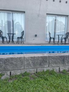 a row of black benches in front of a building at Complejo Bohio in Lobos