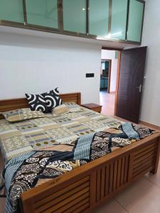 een groot bed met een houten frame in een slaapkamer bij Metro Heights in Parunthumpara