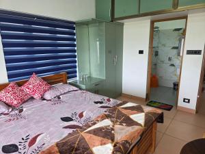 um quarto com uma cama com uma persiana azul em Metro Heights em Parunthumpara