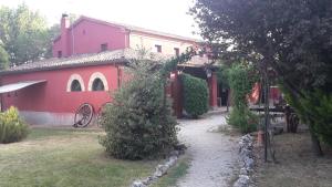 a red house with a pathway in front of it at Agriturismo Case Mori in Rimini