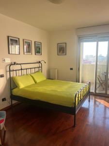 een slaapkamer met een bed met groene lakens en een raam bij terrazza sesto, milano niguarda san raffele in Sesto San Giovanni +2 foto's