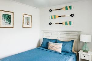 a bedroom with a blue bed and a white wall at Sanderling - Pet Friendly - Walk to Beach - Pool! in Holden Beach +19 photos