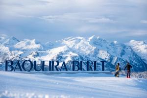 two people standing in the snow next to a sign in the snow at Casa Moline Apartamentos Rurales in Aneto